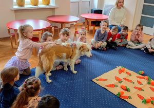 Dziewczynka głaszcze psa.