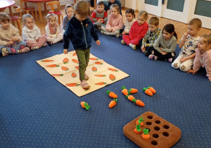 Dziewczynka idzie po marchewkowym dywanie.