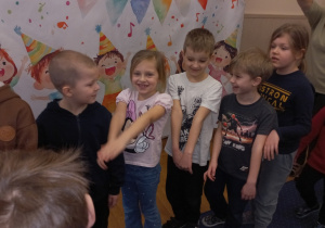 Dzieci tańczą w kole.