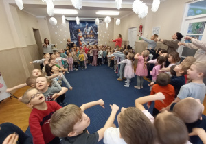 Dzieci tańczą w kole.