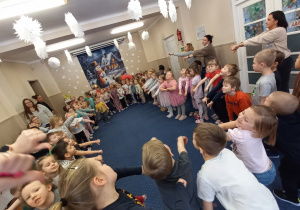 Dzieci tańczą w kole.