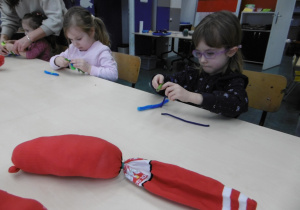 Dziewczynka wkłada watę do czerwonej skarpetki.