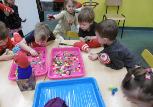 Dzieci przeglądają kolorowe elementy.