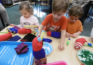 Troje dzieci wyszukuje kolorowe elementy.