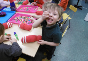 Chłopiec pokazuje biały koralik.