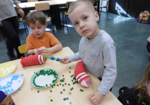 Dwóch chłopców stoi przy stoliku.