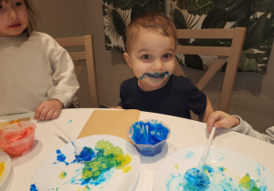 Chłopiec z niebieską bitą śmietaną na ustach.