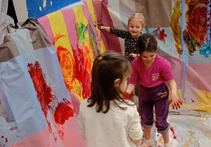 Dziewczynki malują rączkami.