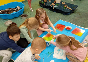 Dzieci bawią się kolorową cieczą.