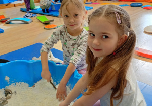 Dziewczynka w białej koszulce i dziewczynka w bluzce z myszkami.