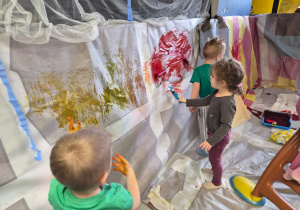 Dzieci malują farbami.