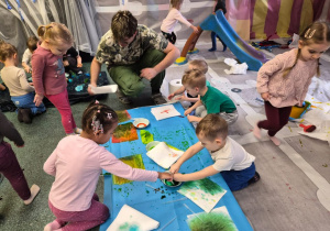 Dzieci bawią się kolorową cieczą.