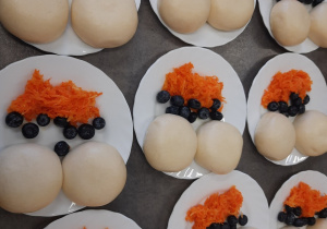 Pampuchy z borówkami i surówką z marchewki.