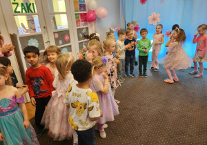 Dzieci tańczą w kole.