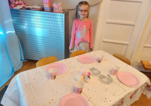 Dziewczynka i jej udekorowany stół.