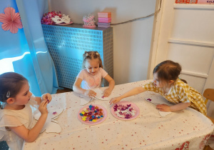 Dziewczynki dekorują motylki.