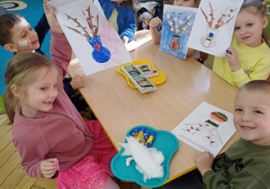 Dzieci siedzą przy stoliku.