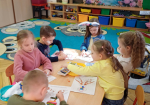 Kolejna grupa dzieci siedzi przy stoliku.