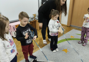 Troje dzieci trzyma sznurki w ręku.