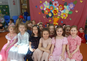 grupa dziewczynek siedzi obok siebie.