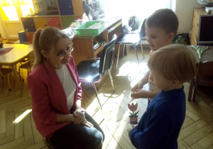 Chopcy wreczają nauczycielce kwiatka.