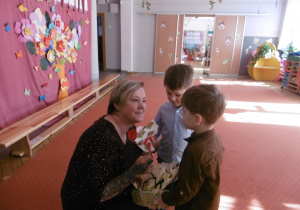 Chłopcy wręczają kawiaty.