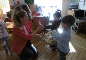 Chłopcy wręczają prezent nauczycielce.