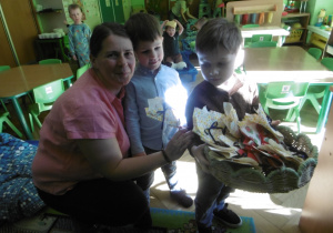 Chłopcy stoją z prezentami przy pani z obsługi.