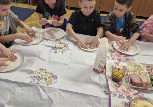 Grupa dzieci siedzi przy stole.