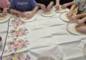 Grupa dzieci siedzi przy stole.