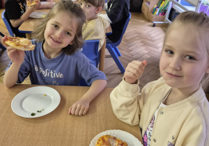 Grupa dzieci smakuje swoje kawałki ciasta.