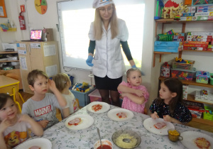 Nauczycielka i dzieci podczas wspólnego posiłku.