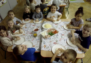 Kolejna grupa dzieci siedzi przy stole.