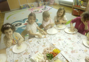 Inna grupa dzieci siedzi przy stole.