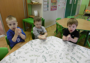 Trzech chłopców trzyma w rękach swoje kawałki ciasta.