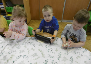 Trzech chłopców siedzi przy stole.