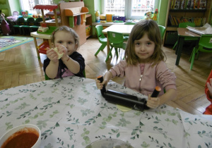 Dwie dziewczynki siedzą przy stole.