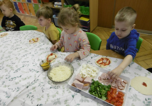 Dwoje dzieci siedzi przy stole.