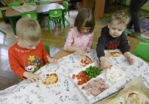 Troje dzieci siedzi przy stole.