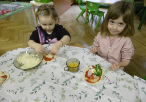 Dwie dziewczynki siedzą przy stole.