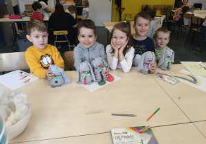 Pięcioro dzieci siedzi przy stole.