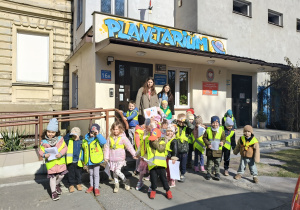 Dzieci stoją przed budynkiem Planetarium.