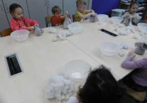 Kolejna grupa dzieci siedzi przy stole i wykonuje prace.