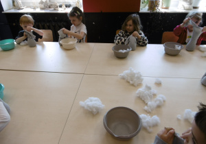 Inna grupa dzieci siedzi i wykonuje prace.