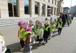 Grupa dzieci stoi przy Teatrze Wielkiem.