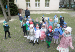 Dzieci stoją obok siebie na terenie placu zabaw.