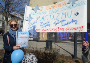 Nauczycielka trzyma transparent.