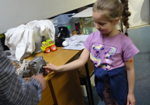 Dziewczynka dotyka urządzenia mechanicznego.