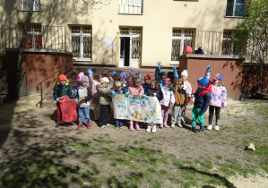 Kolejna grupa dzieci stoi razem z plakatem.