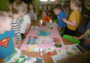 Grupa dzieci stoi razem przy plakacie.